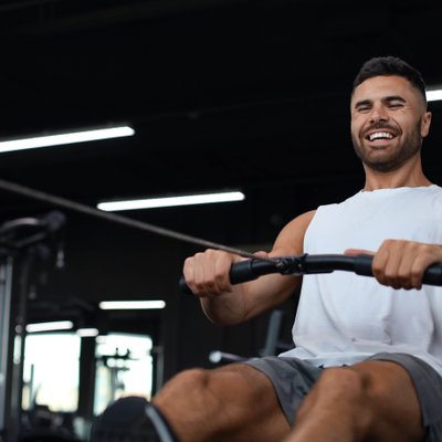 mann-rudern-lachen-fitnessstudio